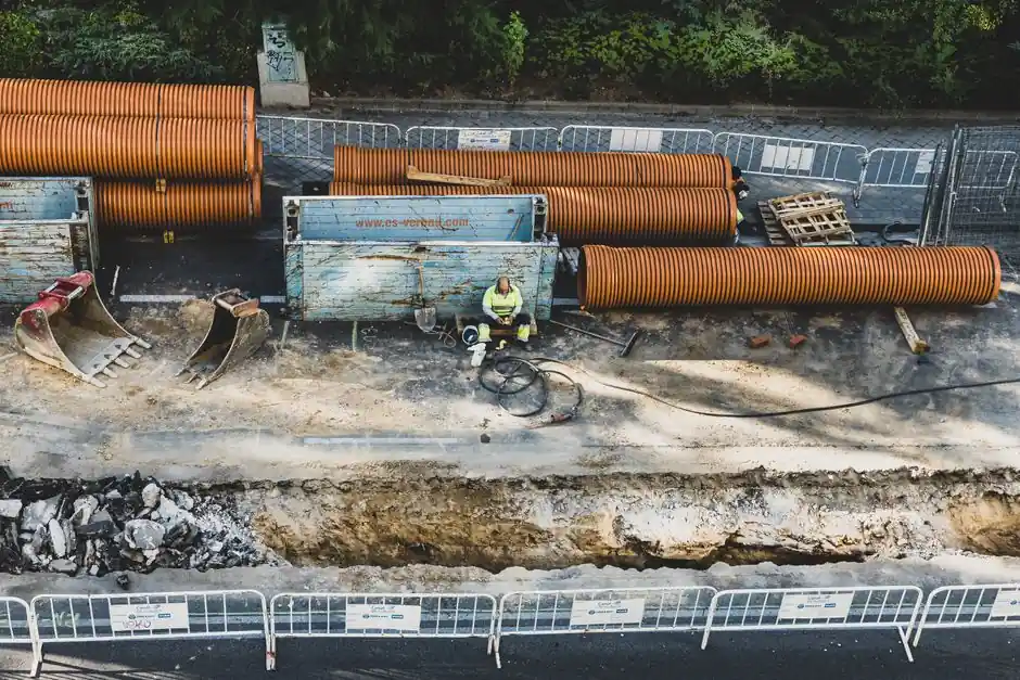 A construction worker takes a break at a site in Madrid, surrounded by equipment and materials.